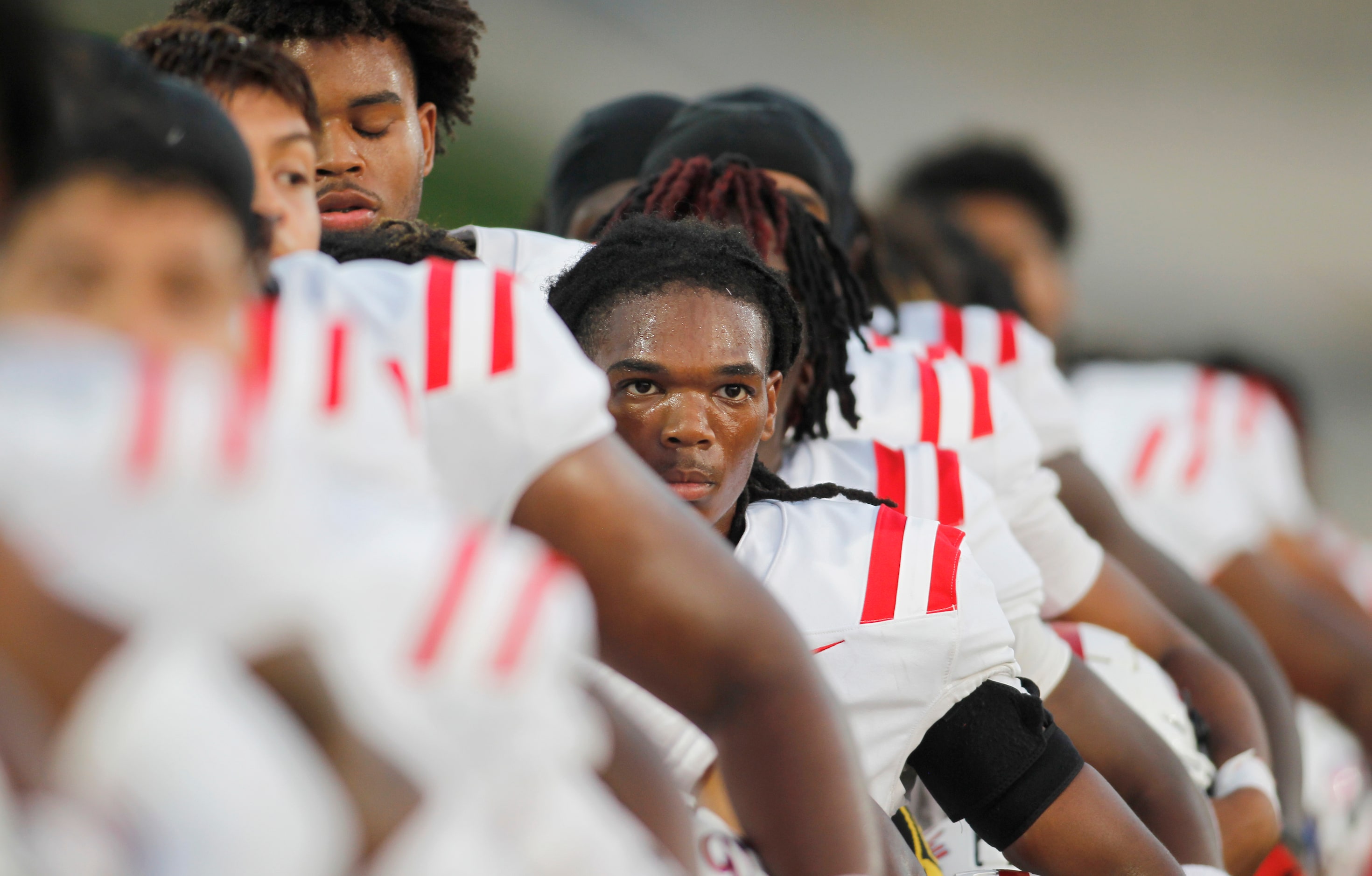 Duncanville players pause for the playing of the national anthem prior to the opening...