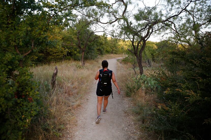 Victoria Rivera hikes along Cattail Pond Trail at Cedar Ridge Preserve in Dallas on Friday,...