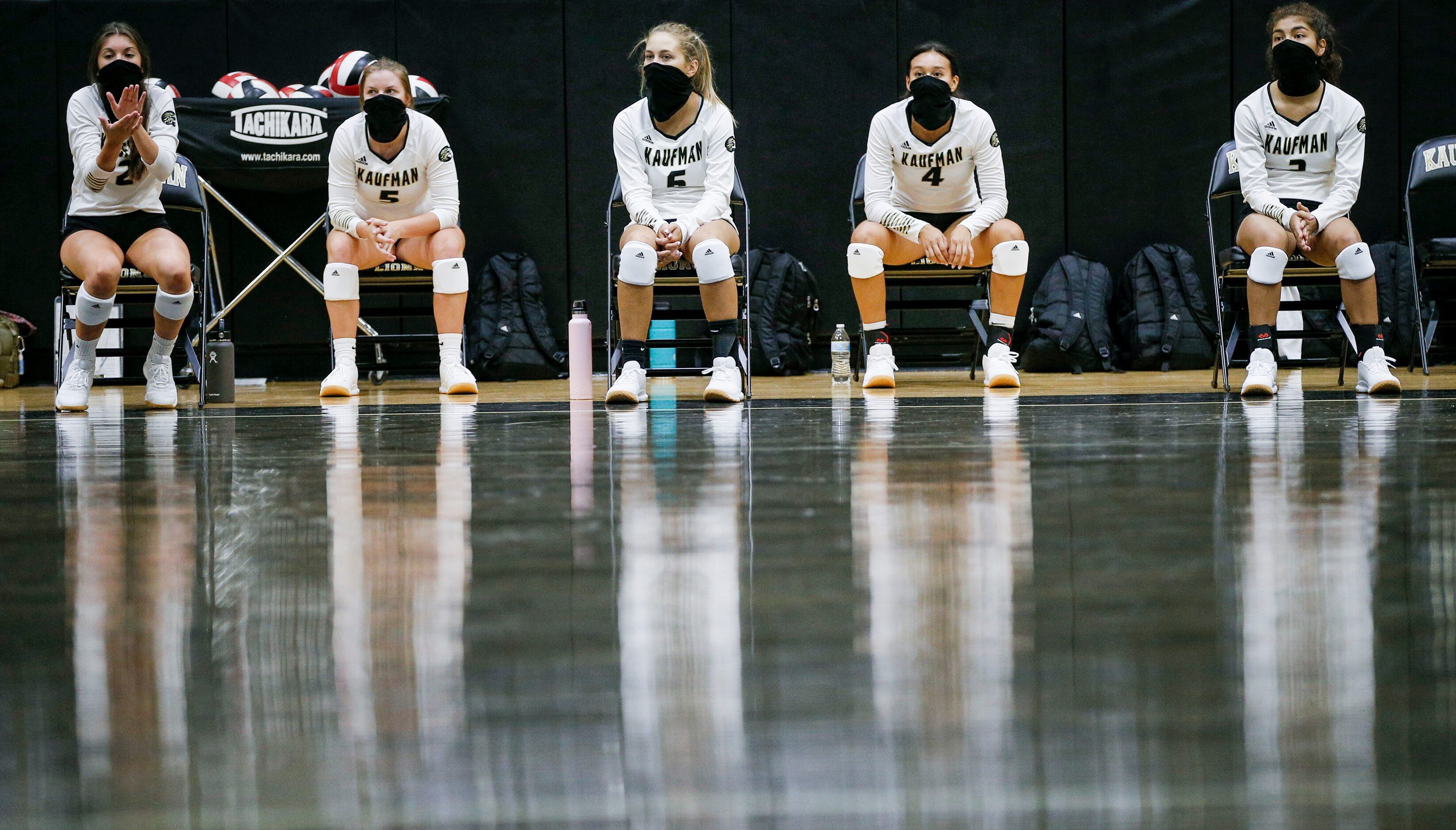 The Kaufman varsity volleyball reserve players wear masks while social distancing on the...