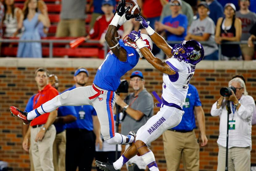 SMU wide receiver Kevin Thomas (1) makes a difficult catch in spite of tight coverage by...