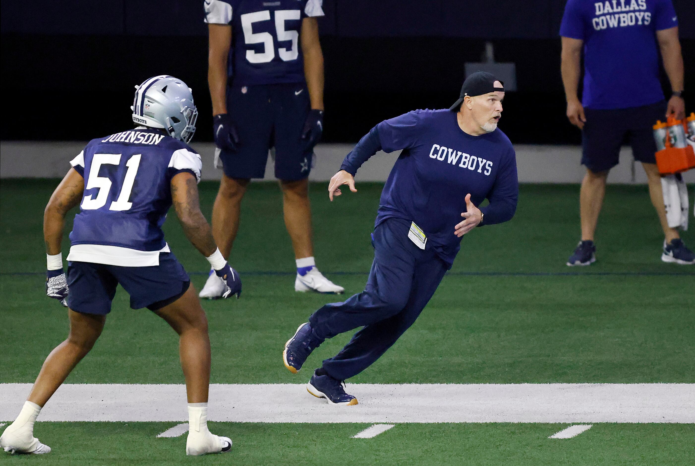 Dallas Cowboys defensive coordinator Dan Quinn runs a route during a mini camp session at...