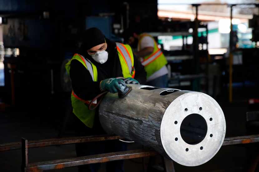 A worker sands a galvanized steel housing at wireless infrastructure manufacturer CommScope...
