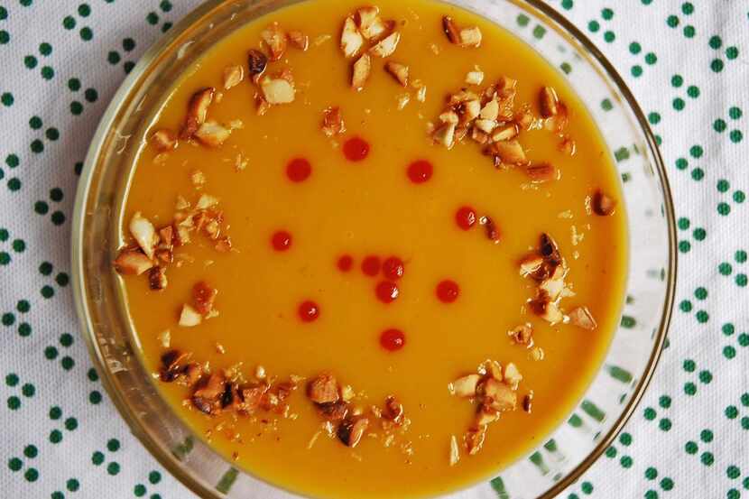 Sweet Potato Bisque is topped with firery sriracha and favorful sauteed peanuts.