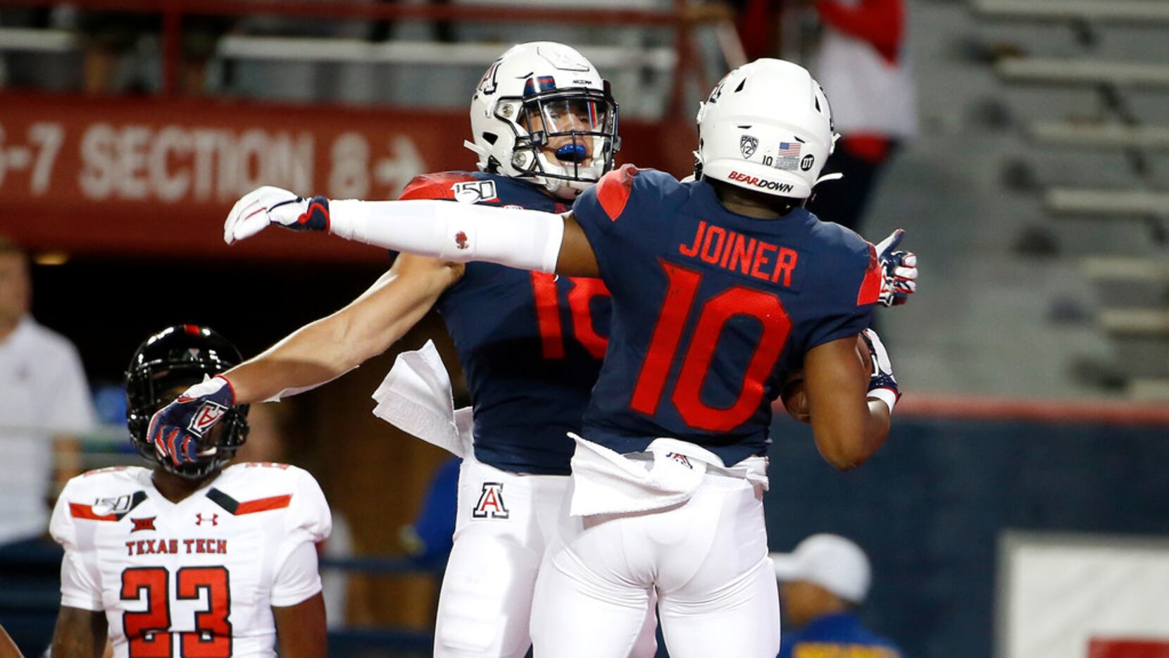 Arizona wide receiver Jamarye Joiner (10) celebrates with teammate Cedric Peterson (18)...