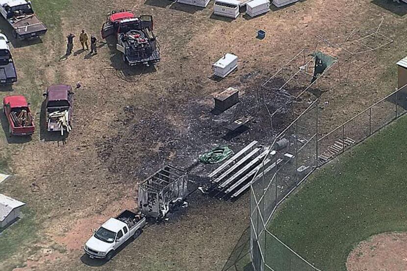 A charred patch of ground and a burned-out trailer mark the site where one person was killed...