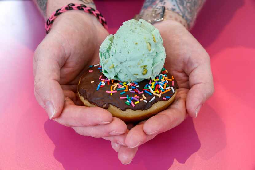 Chef Parker Howard holds a vegan chocolate glazed doughnut with sprinkles and a scoop of...