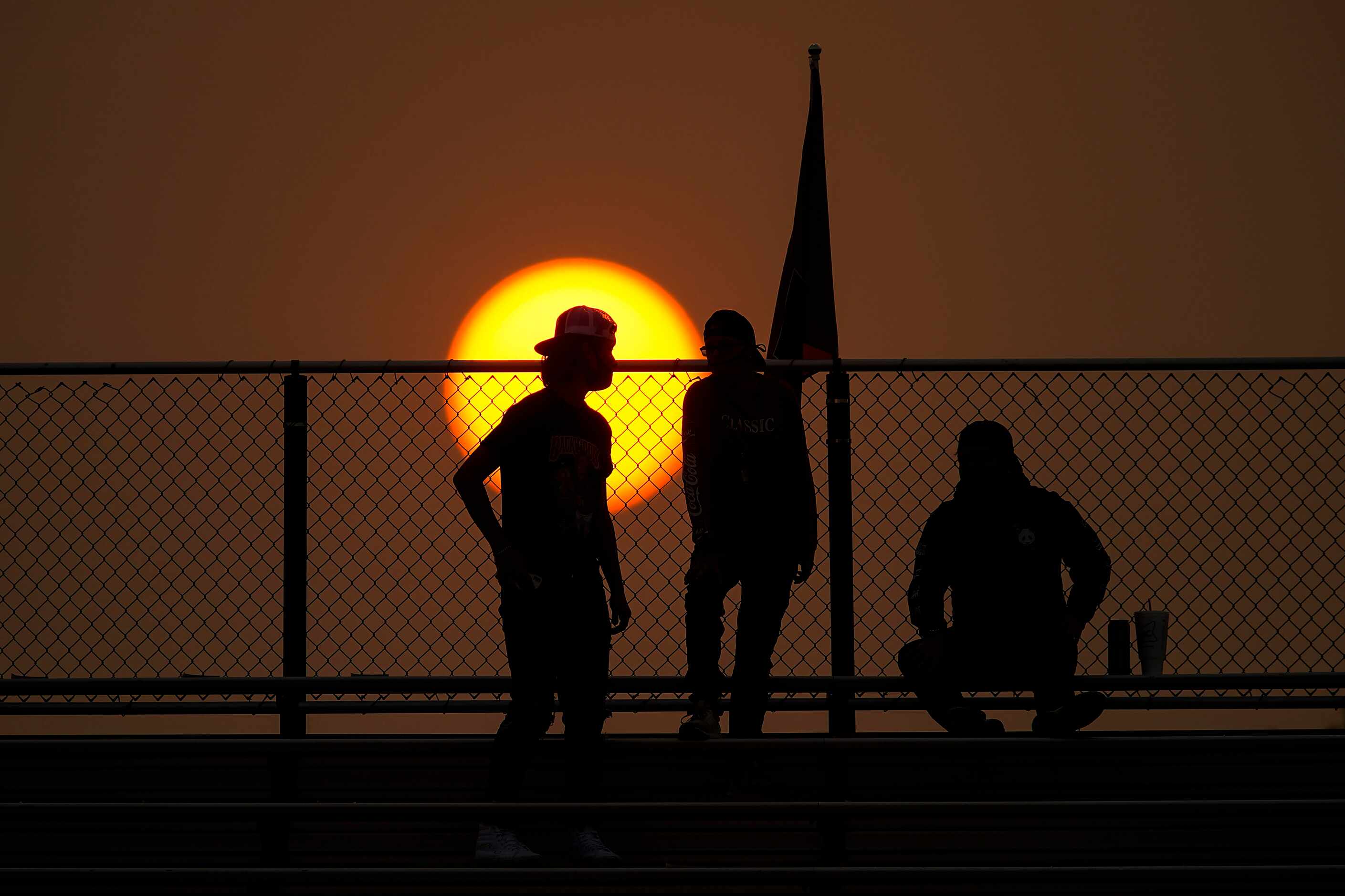 Aubrey fans wait for the game to start as the sun sets on the stadium before a high school...
