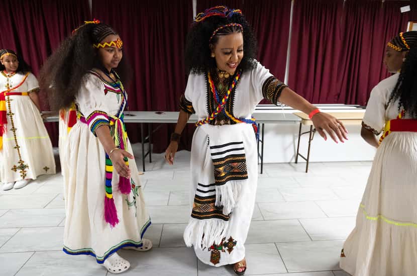 Semehal Yemane, 14, left, practices a dance with instructor and mentor Bethlehem "Betty"...