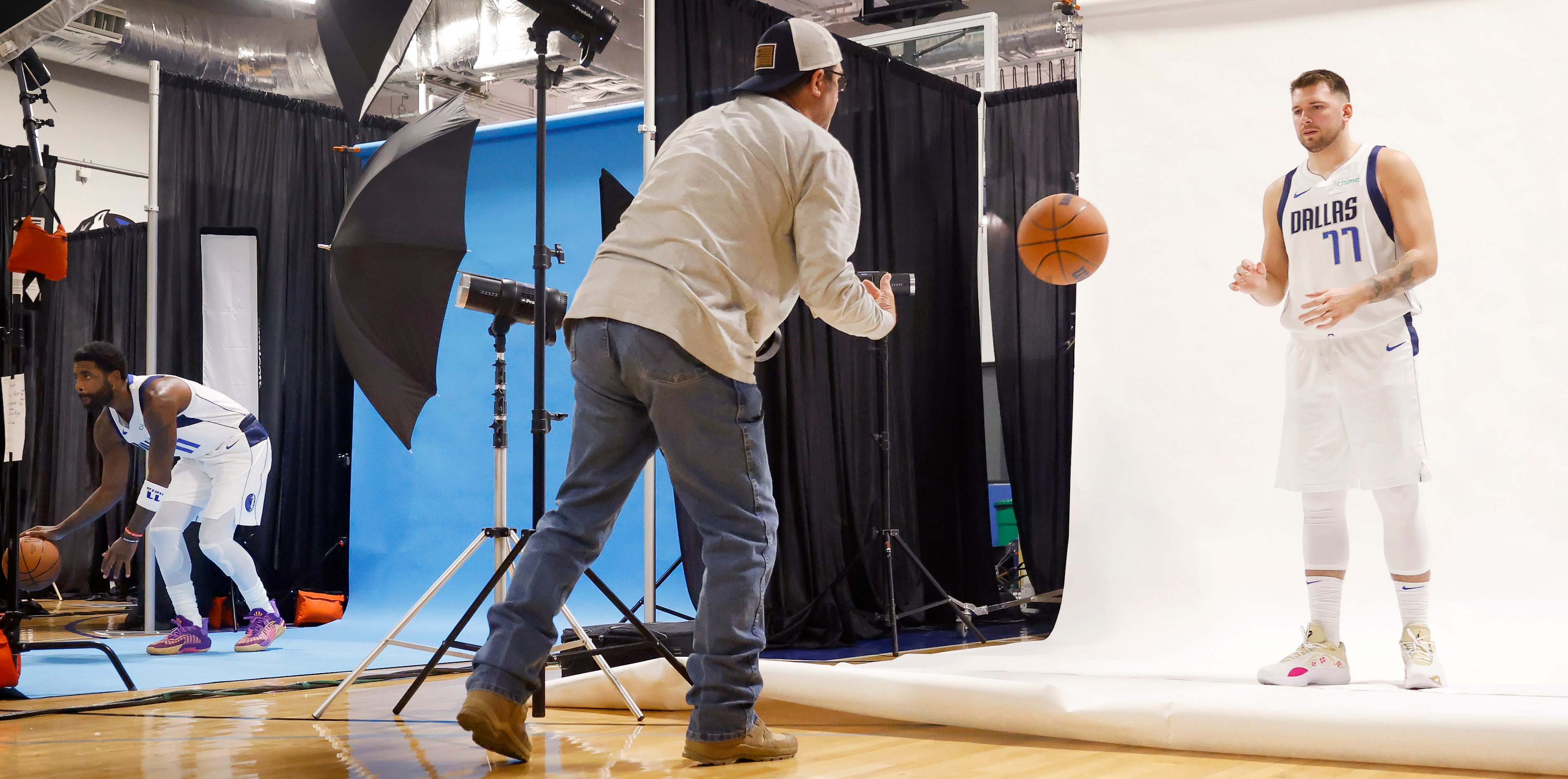 Photographer Glenn James flips Dallas Mavericks guard Luka Doncic (77) a basketball for a...