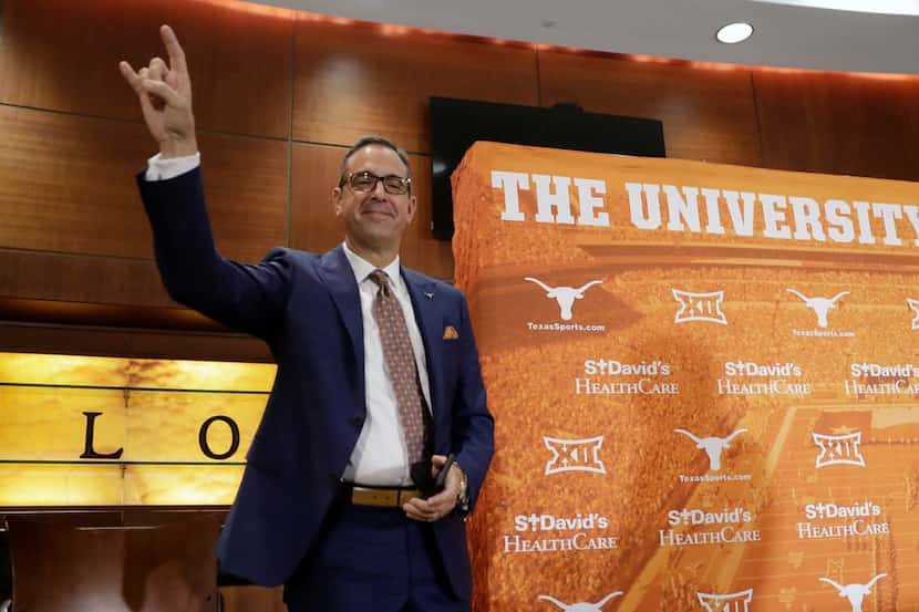 Chris Del Conte holds up the Hook'em sign at a news conference where he was introduced at...