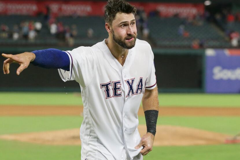 Texas Rangers Joey Gallo points after being doused by teammates after a baseball game in...