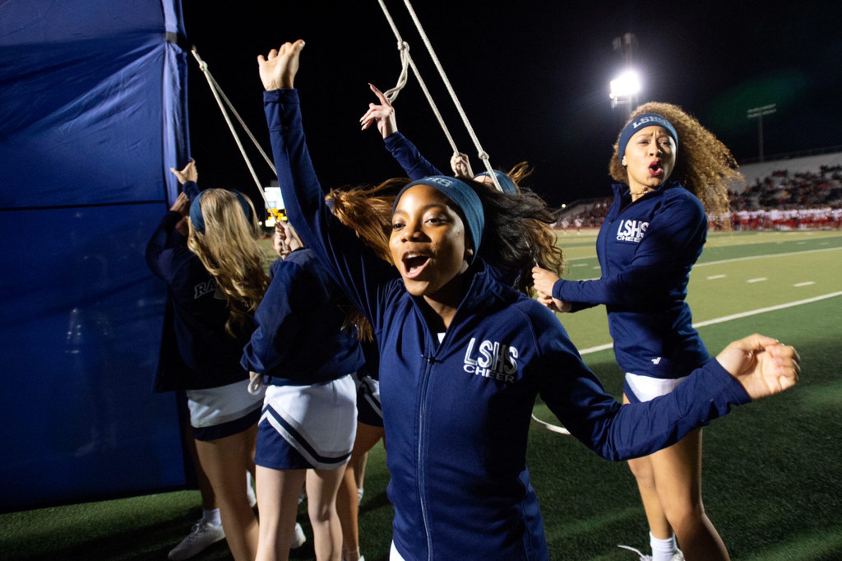 Frisco Lone Star cheerleaders prepare for their team to run through the banner before a...