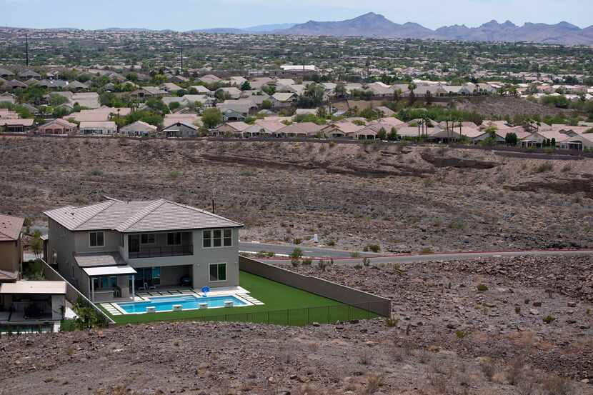 A home with a swimming pool abuts the desert on the edge of the Las Vegas valley, Wednesday,...