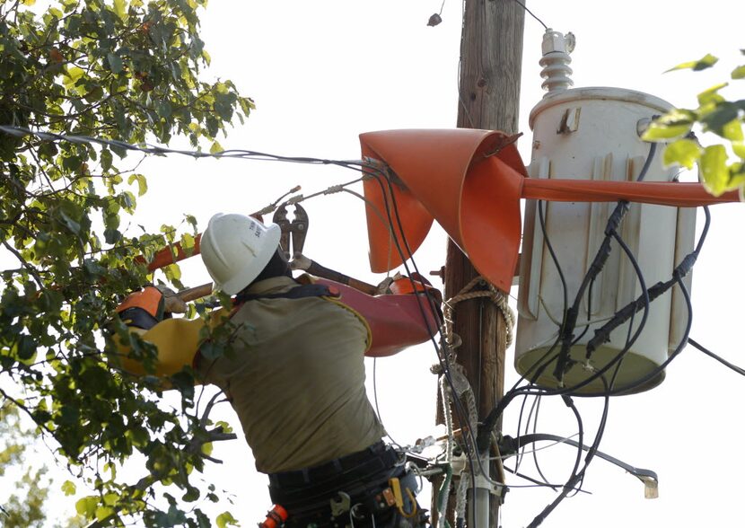 Oncor's Kutter Werning rewires a power line to a transformer in Grand Prairie. (Vernon...