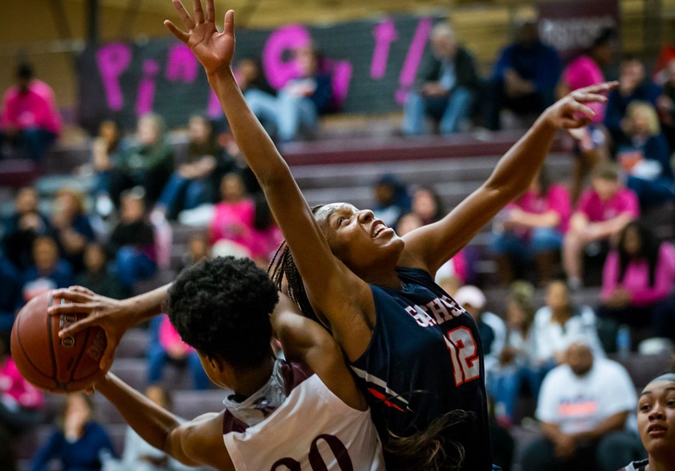 Sachse guard Tia Harvey (12) fights for a rebound against Rowlett forward Ngozi Obineke (20)...