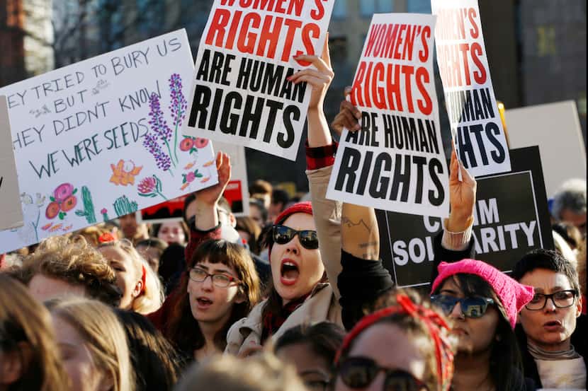 Women chant and hold signs during a rally and march on a A Day Without Women, part of...