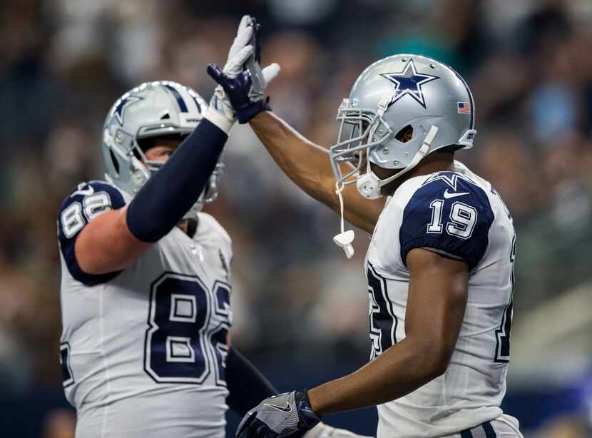 Dallas Cowboys wide receiver Amari Cooper (19) high-fives tight end Jason Witten (82) after...