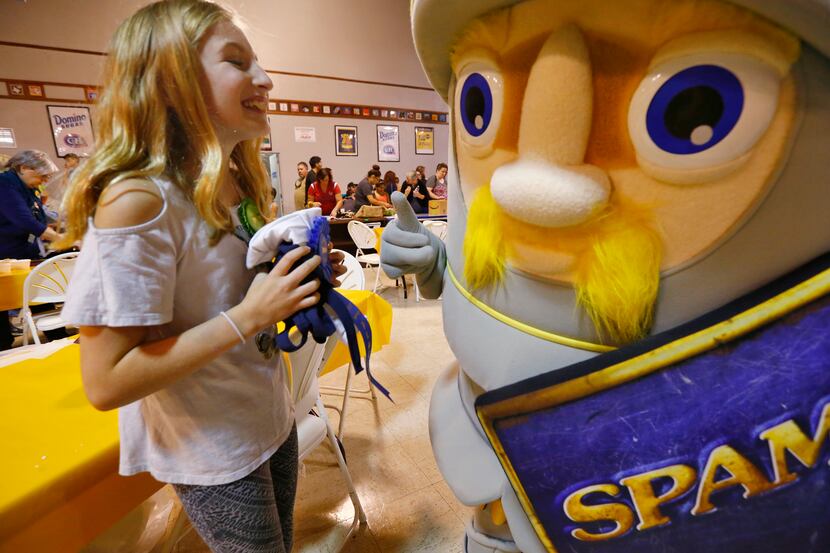 Allyson Garmon, 11, laughs with the Spam mascot, Sir Can-A-Lot, after winning the Kid Chef...