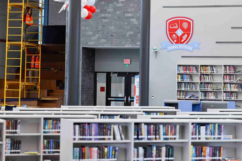 Construction workers work at one side of the newly renovated library at Thomas Jefferson...