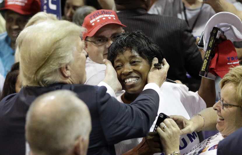 Donald Trump reaches out to hug an African-American supporter after a rally in The Woodlands...
