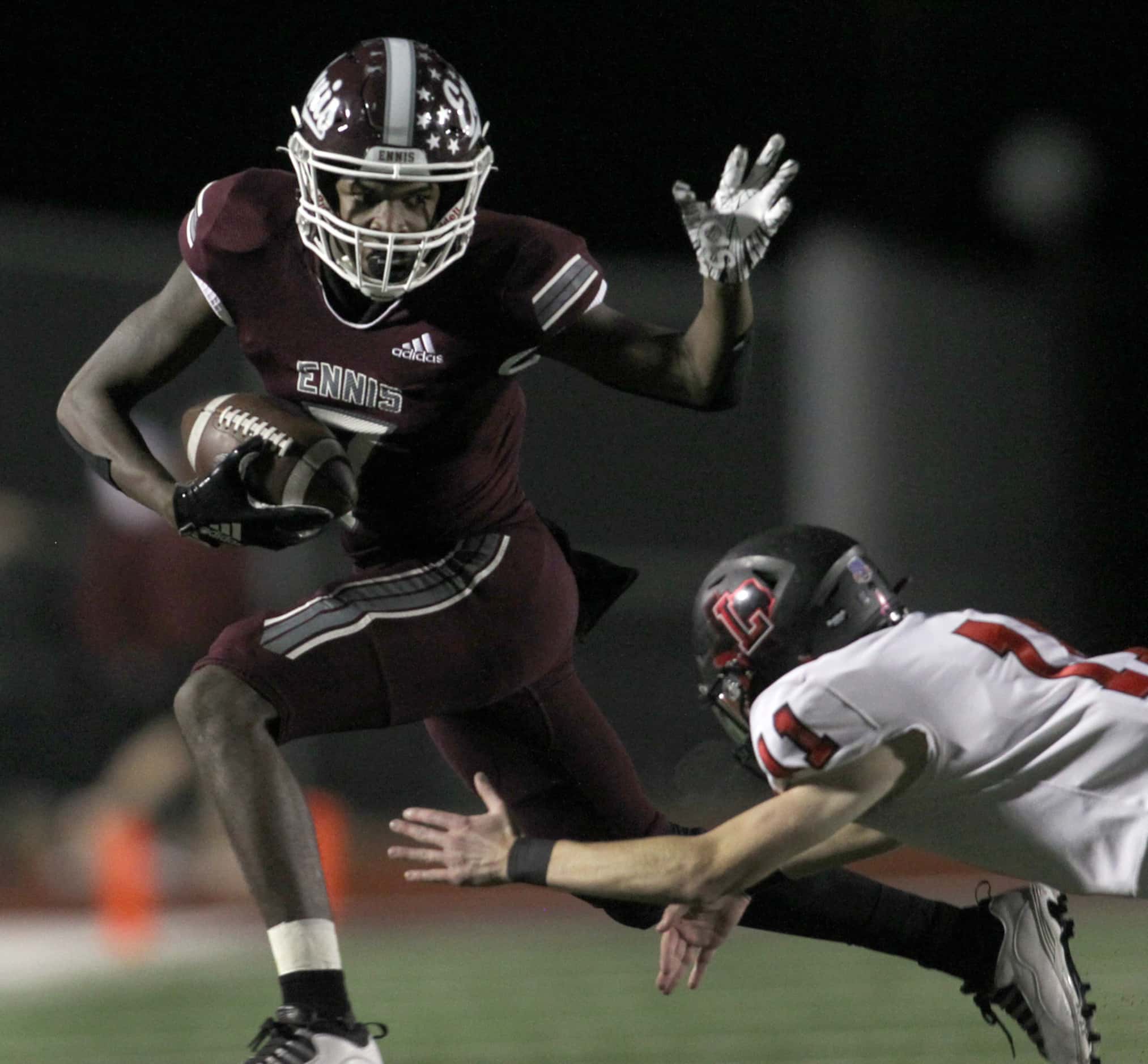 Ennis receiver Laylon Spencer (7) avoids the diving tackle of Frisco Liberty defensive back...