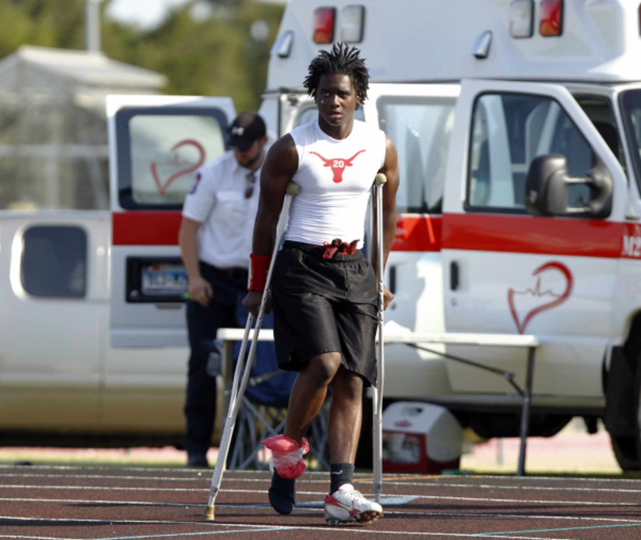Cedar Hill's Kiedek Berry (20) hobbles on crutches after suffering an ankle injury during...