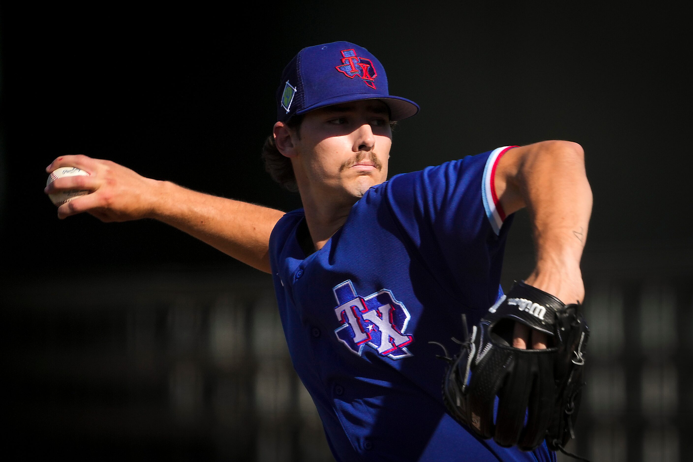 Texas Rangers pitcher Cole Winn delivers during the sixth inning of a spring training game...