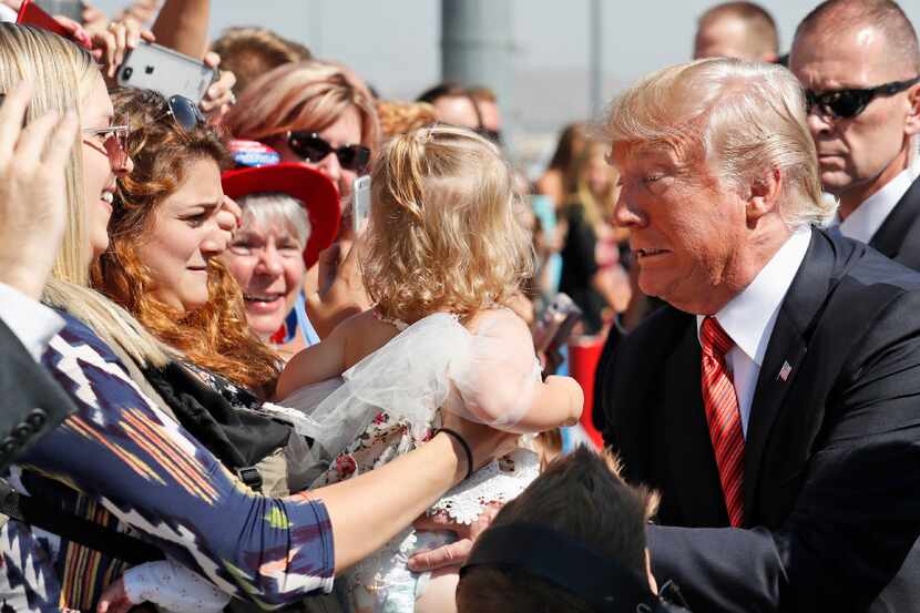 President Donald Trump was handed a supporter's baby as he greeted a crowd upon arriving in...