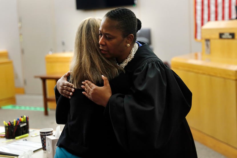State District Judge Tammy Kemp gives fired Dallas police officer Amber Guyger a hug before...