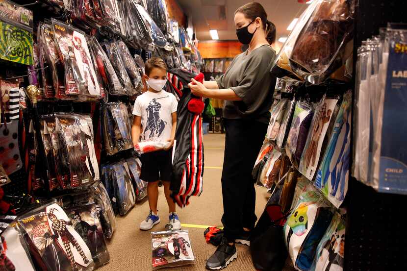 Carey Marin of Richardson sees if a twisted circus clown outfit will fit her son, Joshua, at...