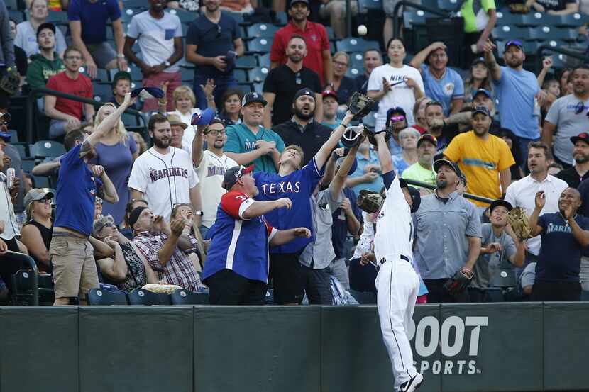SEATTLE, WA - JULY 22: Kyle Seager #15 of the Seattle Mariners gets tangled up with fans...