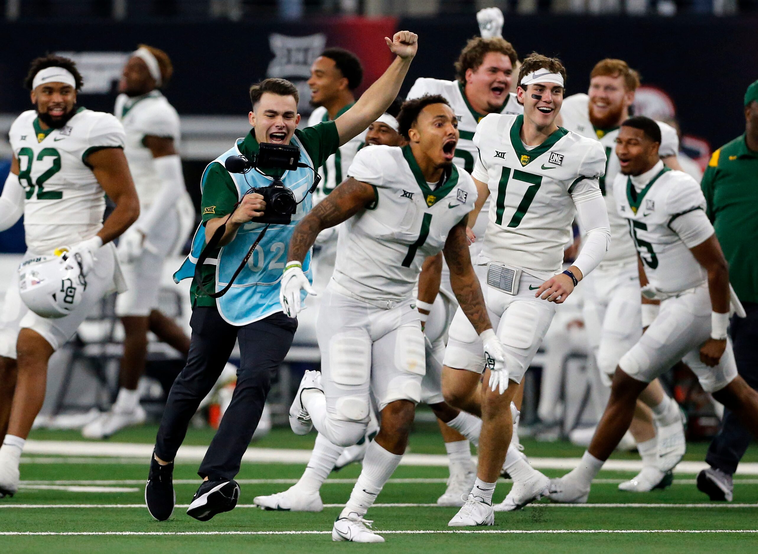 A school photographer (blue smock) celebrates with Baylor Bears running back Trestan Ebner...