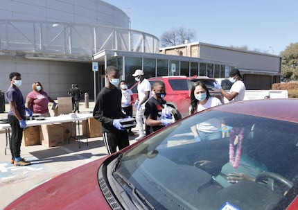 A team of people at Mattie Nash Myrtle Davis Recreation Center hand out hot food from Off...