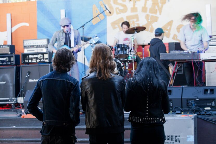 Gus Baldwin, John Kuzmick and Leah Lane of Moon Waves stand up front as they listen to War...