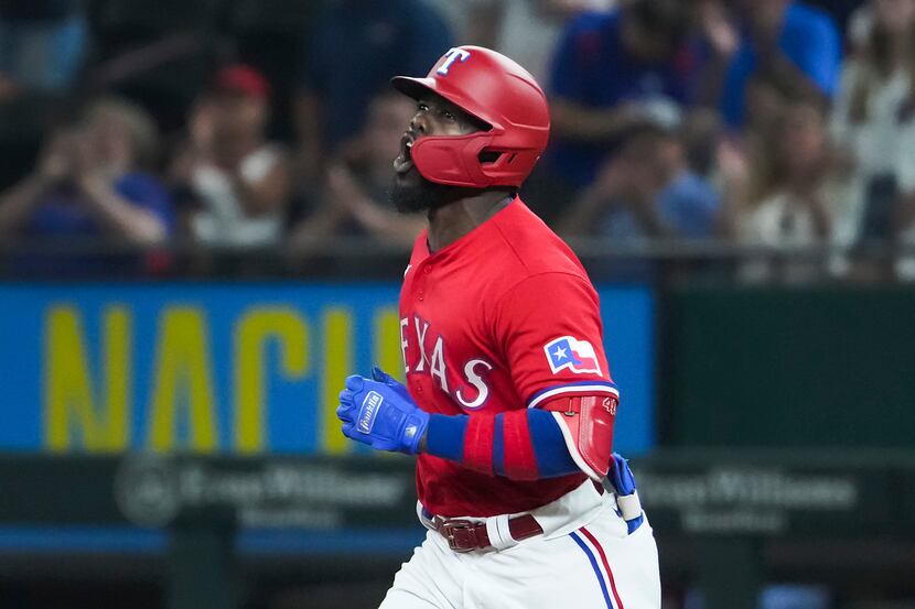 Texas Rangers center fielder Adolis Garcia celebrates as he rounds the bases after hitting a...