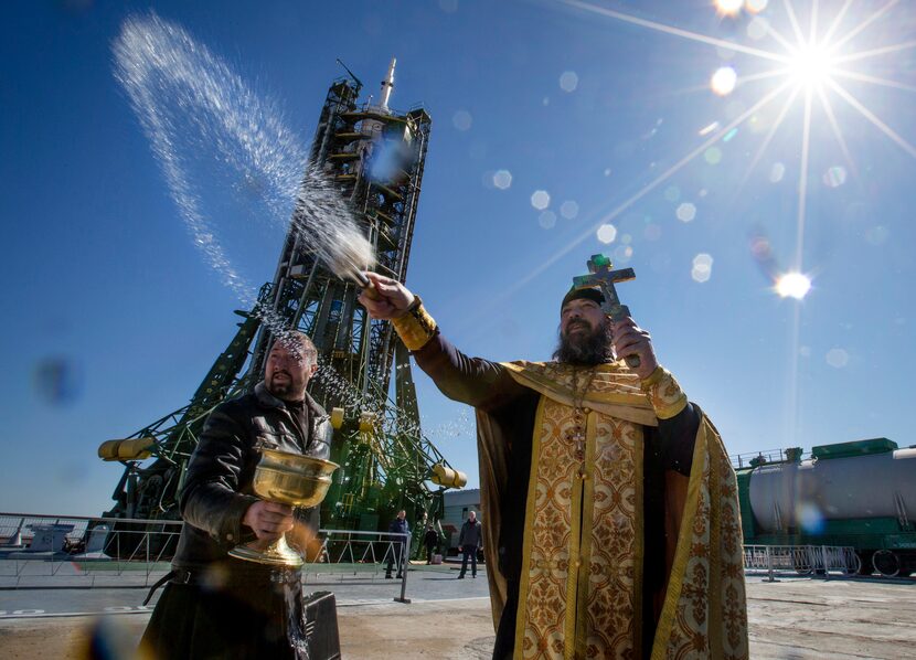 An Orthodox priest conducts a blessing service in front of the Soyuz TMA-16M spacecraft.