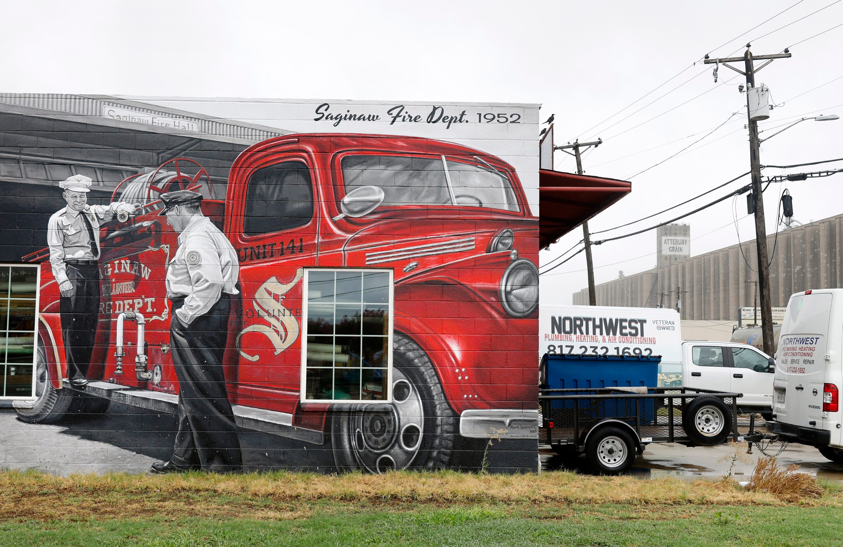 A historical painted mural on the side of Northwest Plumbing, Heating and AC depicts the...