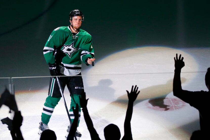 Dallas Stars center Radek Faksa (12) tosses his puck into the crowd after being recognized...