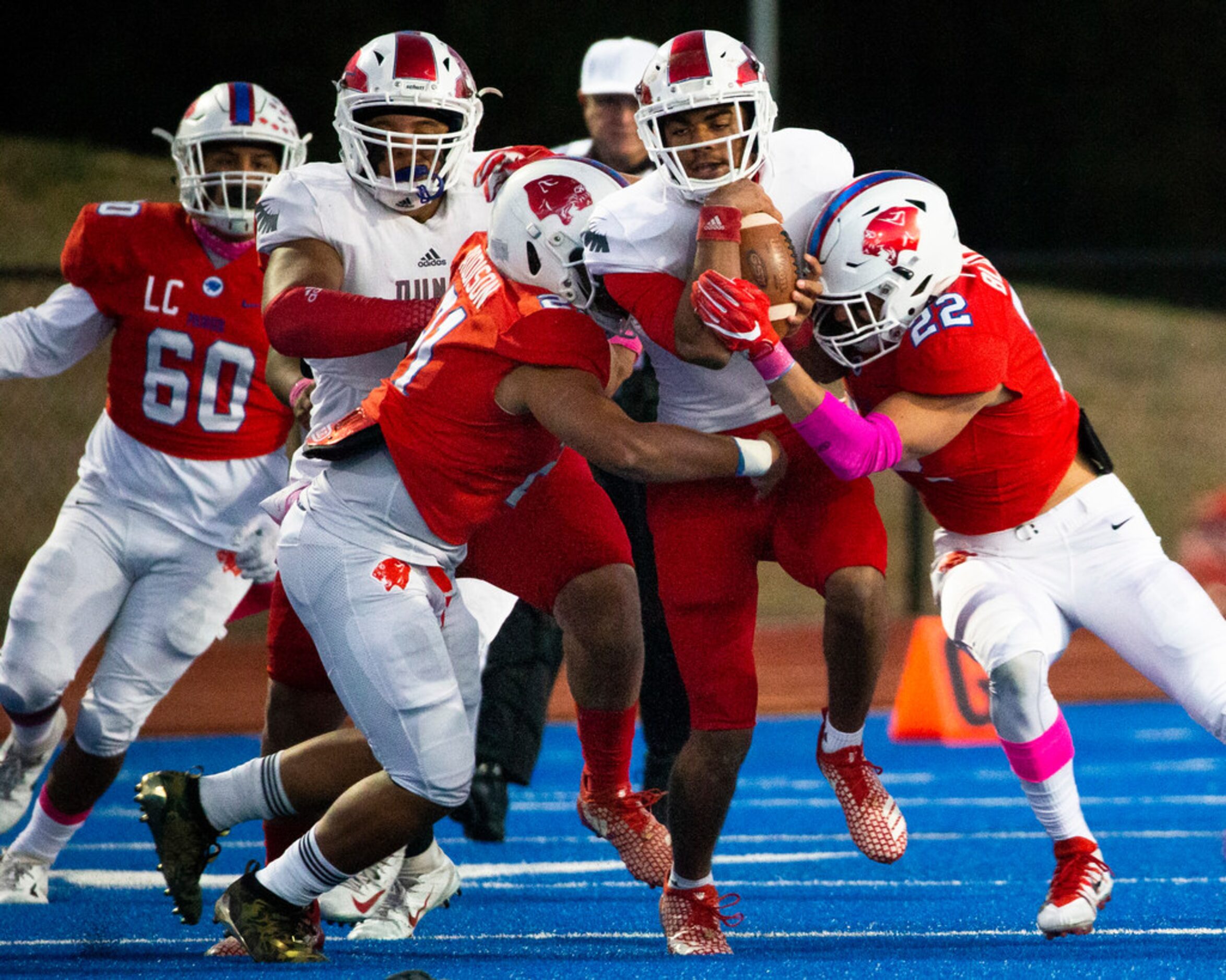 Bishop Dunne quarterback Simeon Evans (center, 1) gets taken down by Parish Episcopal...