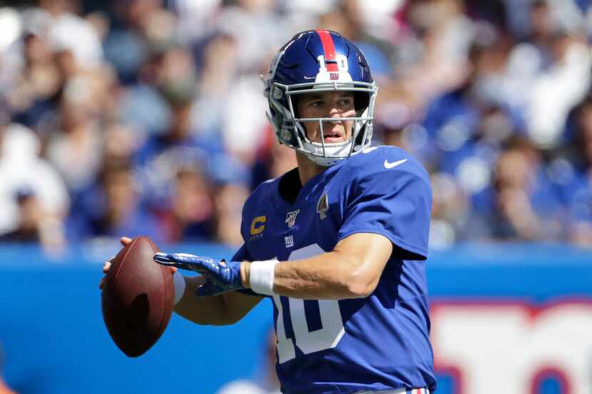 New York Giants quarterback Eli Manning throws during the first half of an NFL football game...