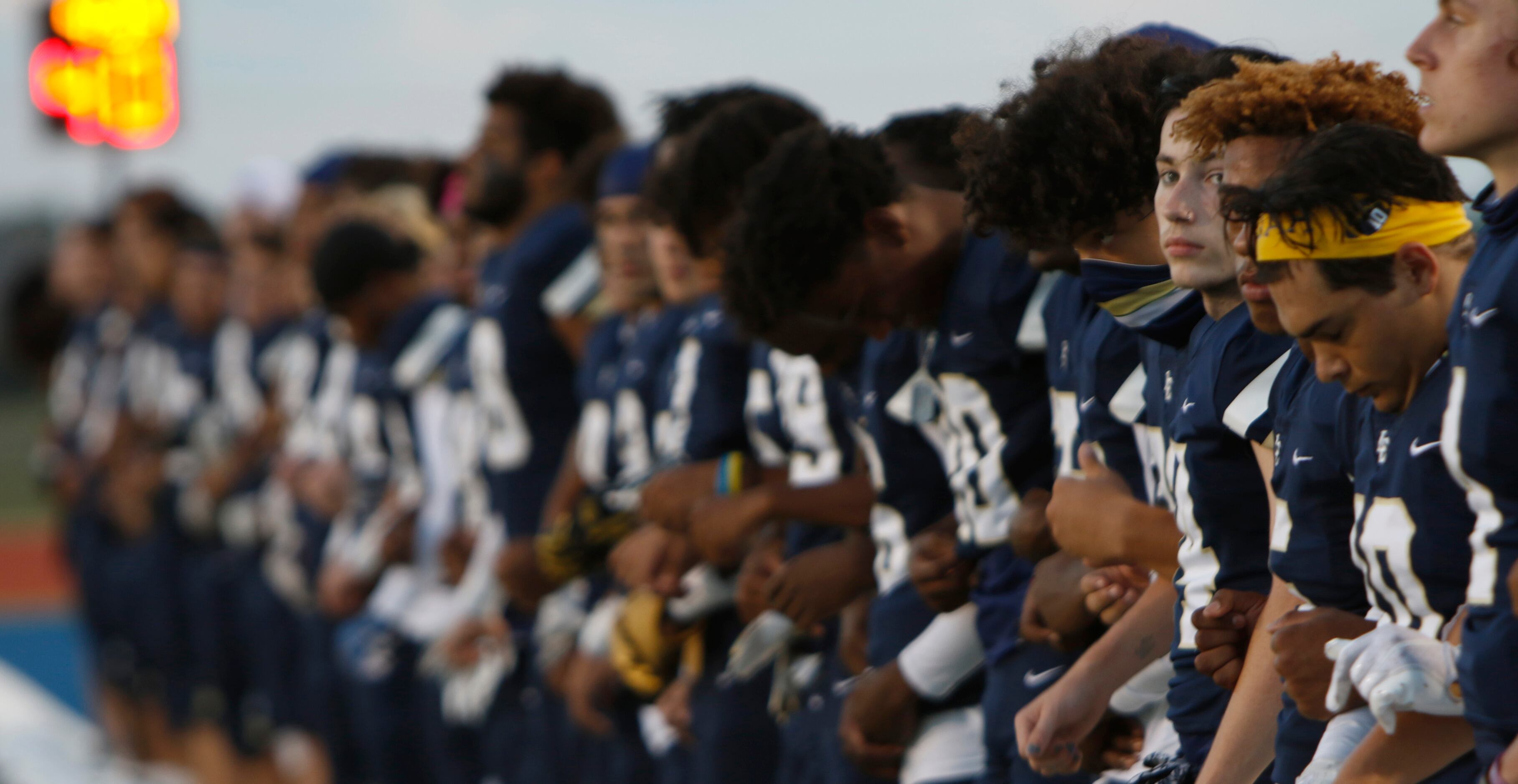 Members of the Little Elm Lobos pause for the playing of the national anthem prior to the...