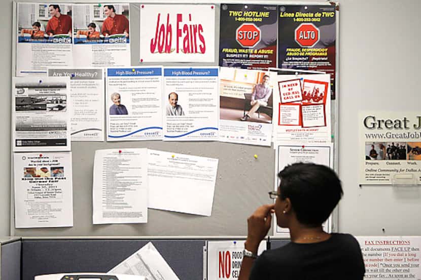 Una persona que busca empleos lee el boletín de la Comisión Laboral de Texas en un centro de...