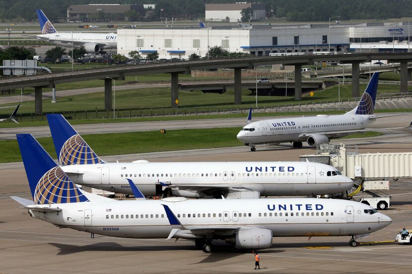 FILE - In this July 8, 2015, file photo, a United Airlines plane, front, is pushed back from...