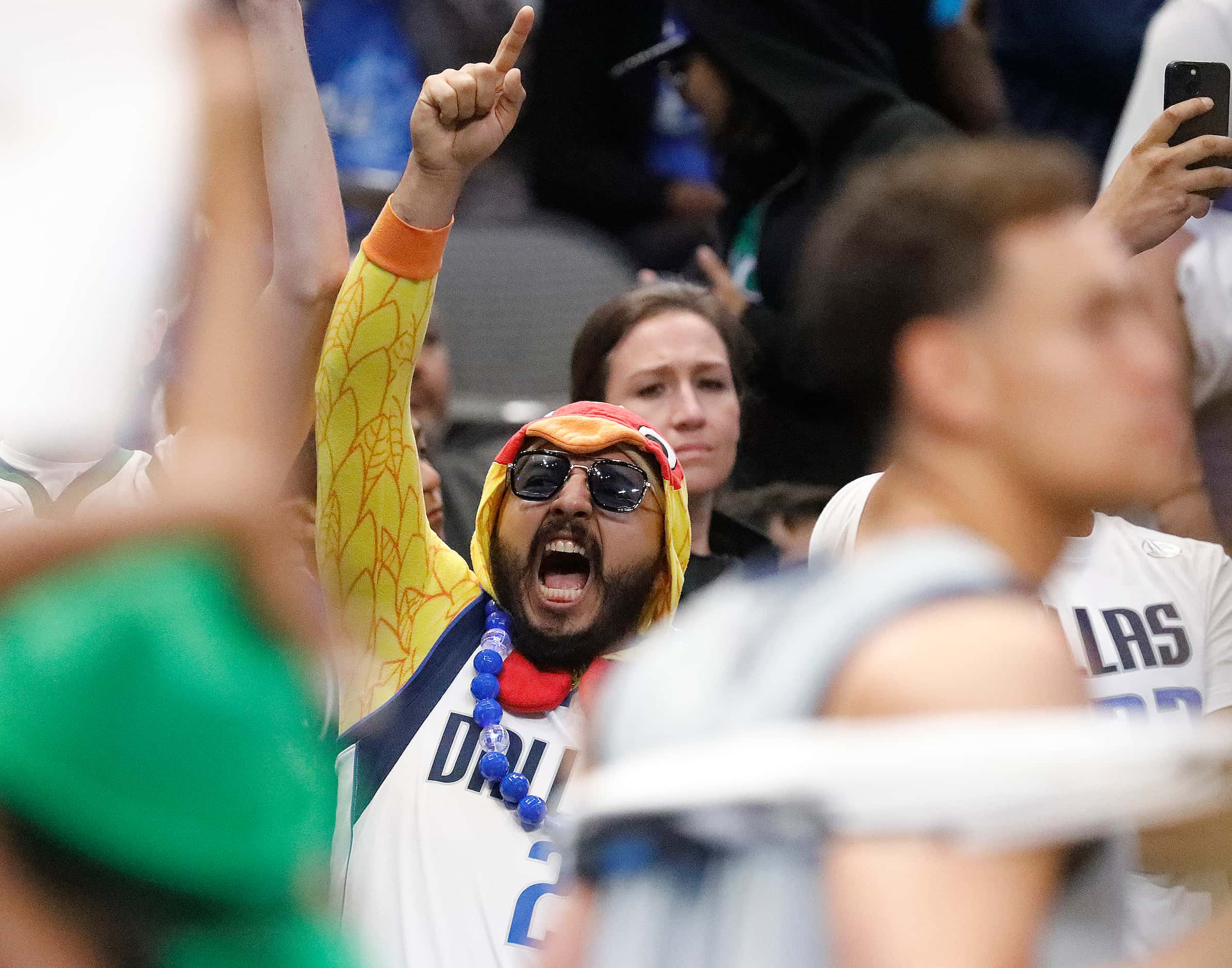 A Mavericks fan dressed as a chicken cheers a play at the Mavs Fan Jam, a free scrimmage for...