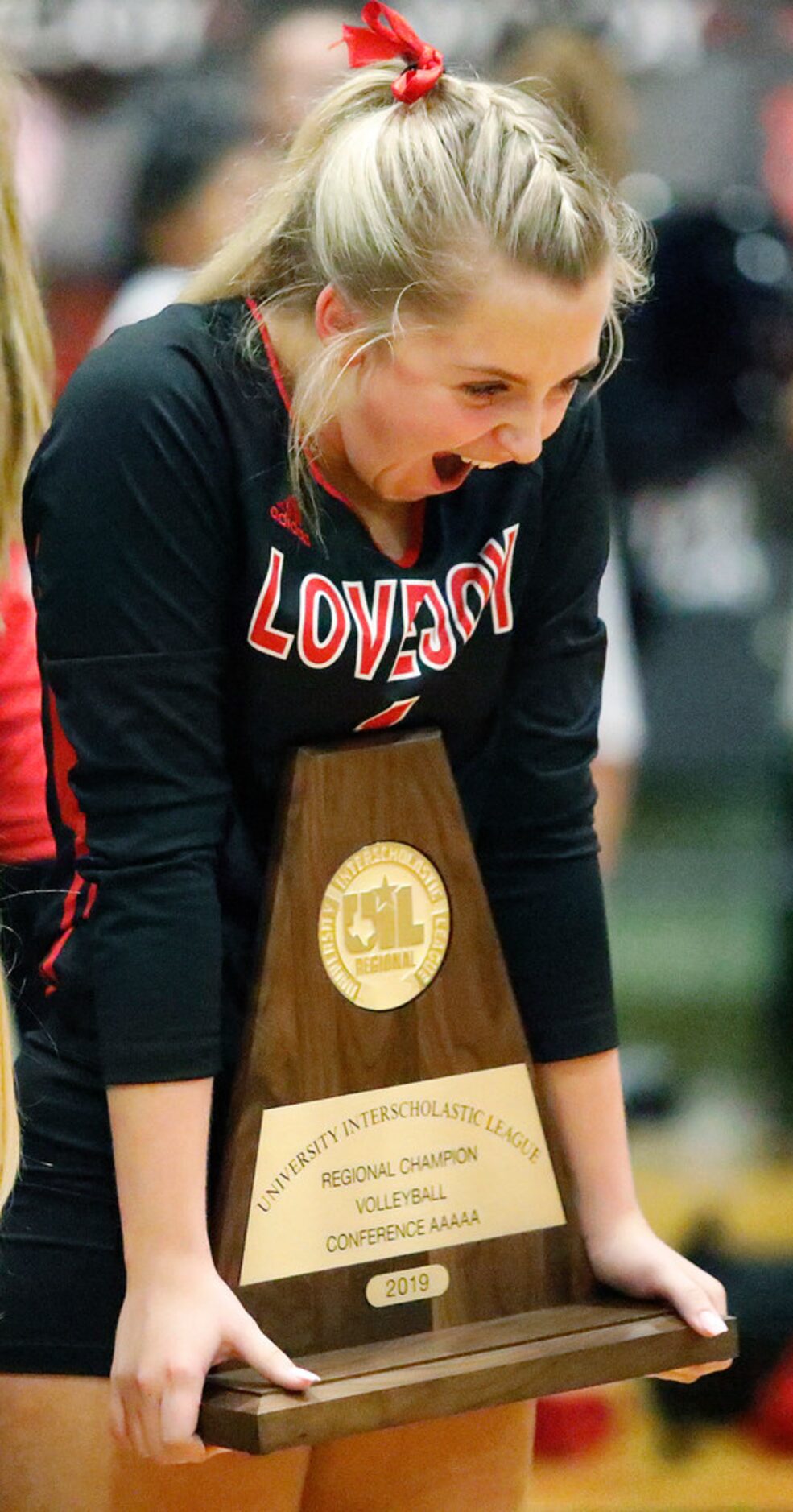 Lovejoy High School defensive specialist Mckenna Franks (1) holds the championship trophy...