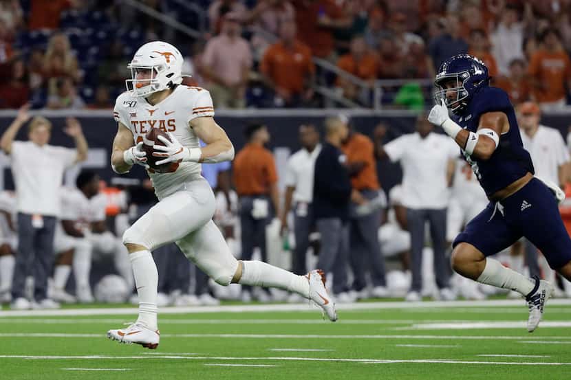 FILE - Texas wide receiver Jake Smith races to the end zone after making a catch past Rice...