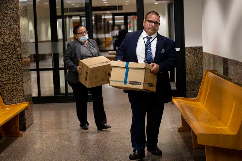 Dallas Police detectives Christine Ramirez (left) and Jose Ortiz Vives carried in boxes of...