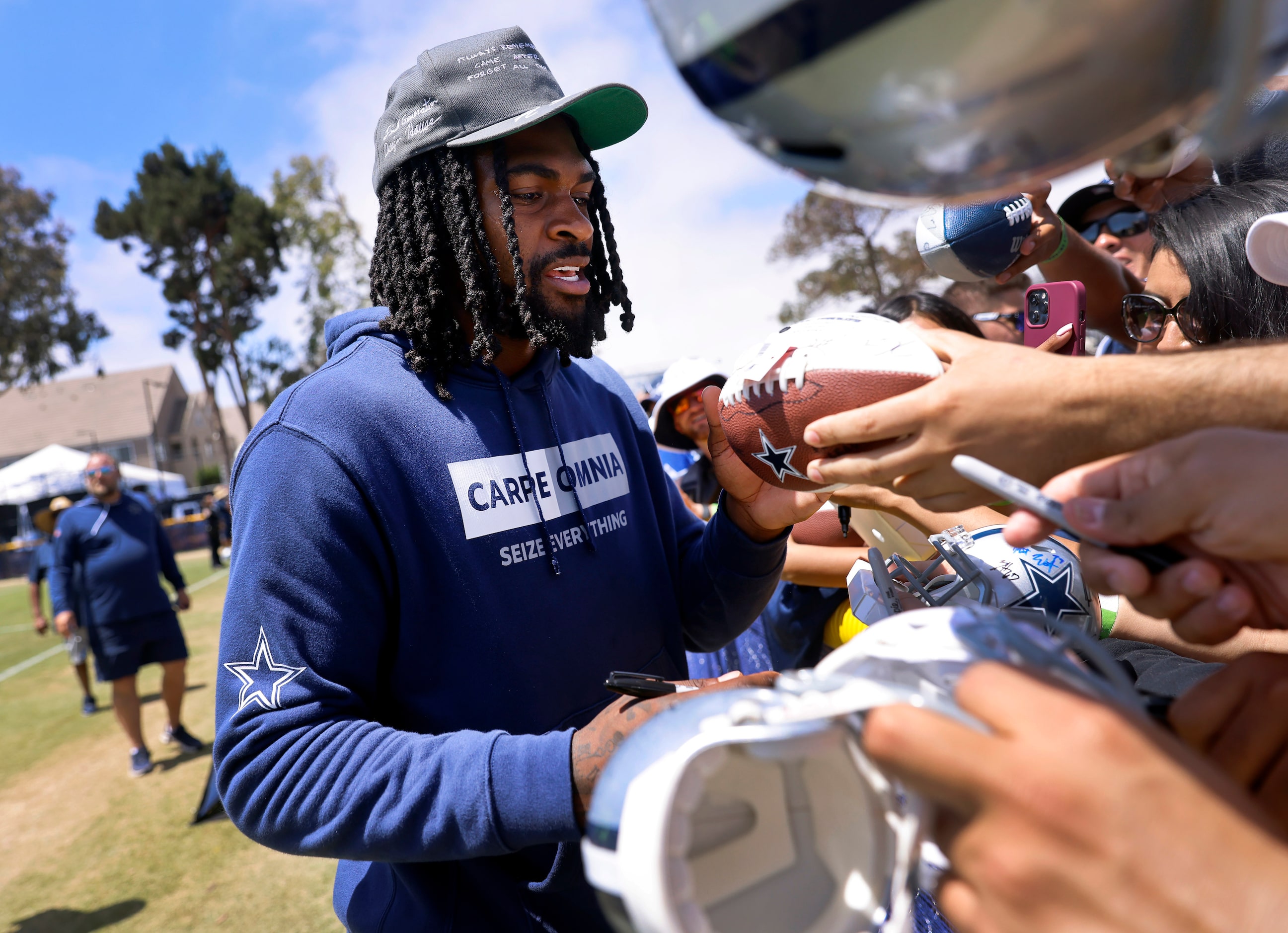 Dallas Cowboys cornerback Trevon Diggs signs autographs for fans following a training camp...