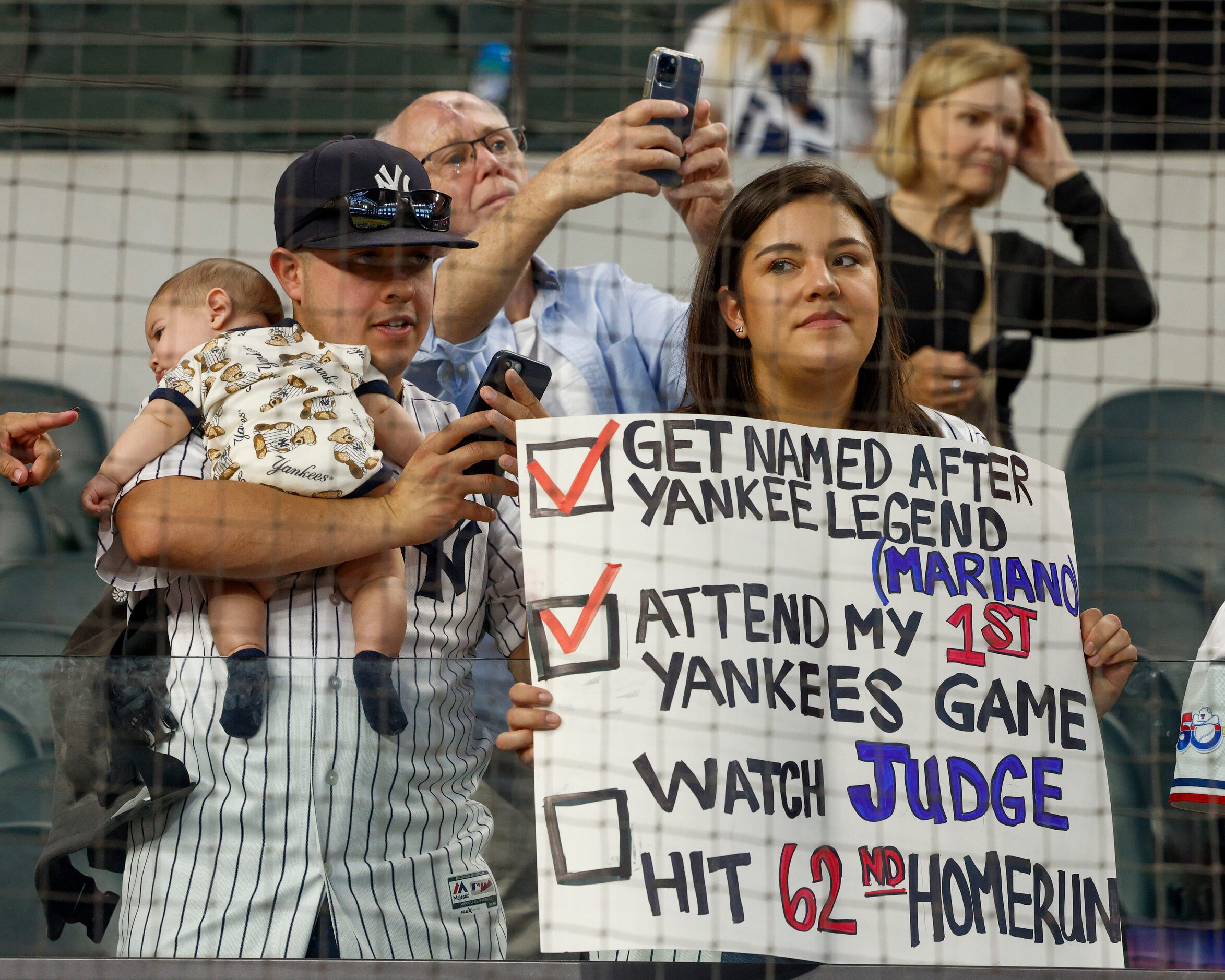 New York Yankees fans hold a sign before a MLB game against the Texas Rangers at Globe Life...