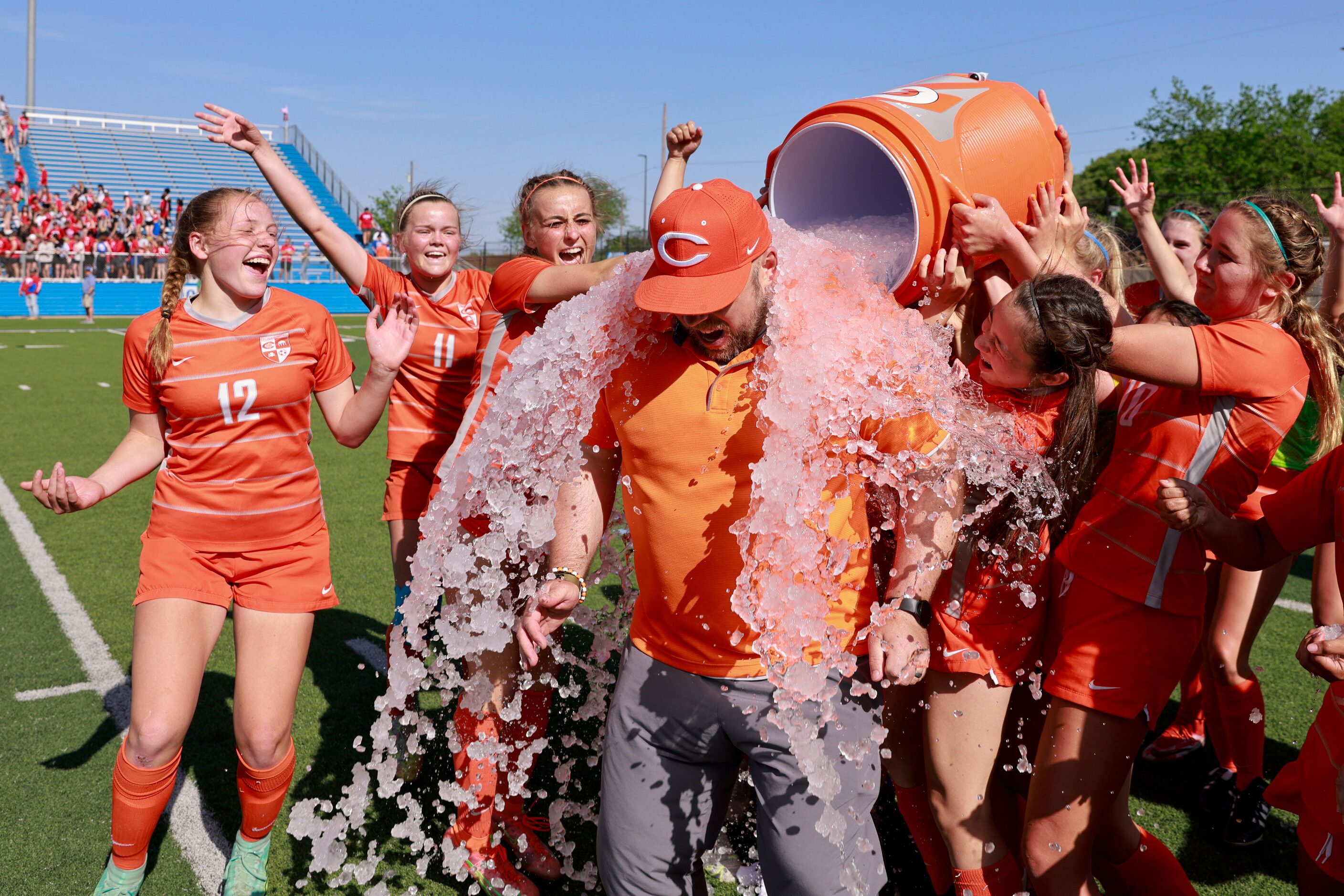 Celina players dose Celina head coach Alexander Adams with water after winning the Class 4A...